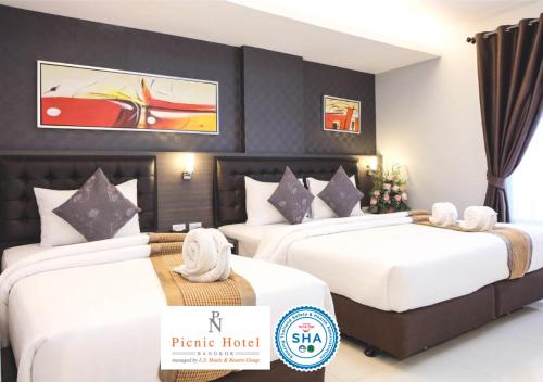 a hotel room with two beds with white sheets at Picnic Hotel Bangkok - Rang Nam in Bangkok