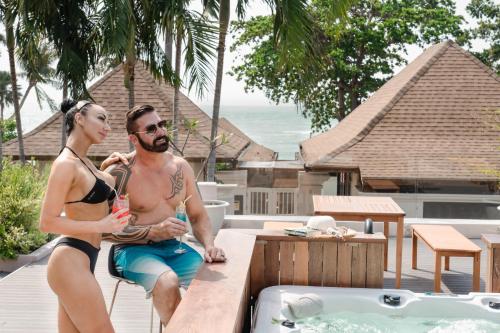 a man and woman sitting on a table next to a tub at The Briza Beach Resort, Samui - SHA Plus in Chaweng