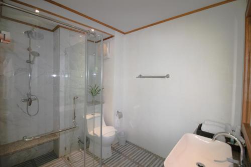 a bathroom with a glass shower and a toilet at Royal Train Garden Resort in Chiang Mai