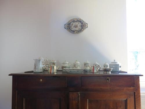 a wooden cabinet with a bunch of dishes on it at Au Relais de Nèche. in Bègues