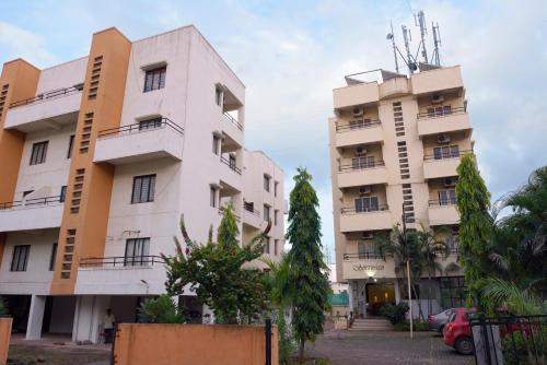 two tall buildings with trees in front of them at Sorrento Homes in Pune