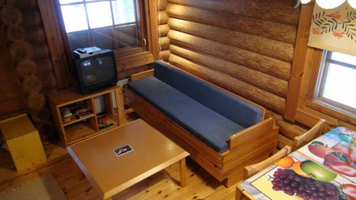 a living room with a blue couch and a tv at cottage 118 in Savonlinna