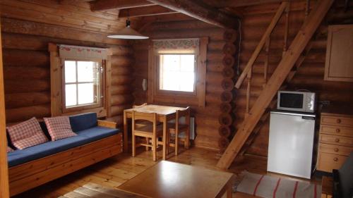 a living room with a blue couch in a log cabin at cottage 118 in Savonlinna