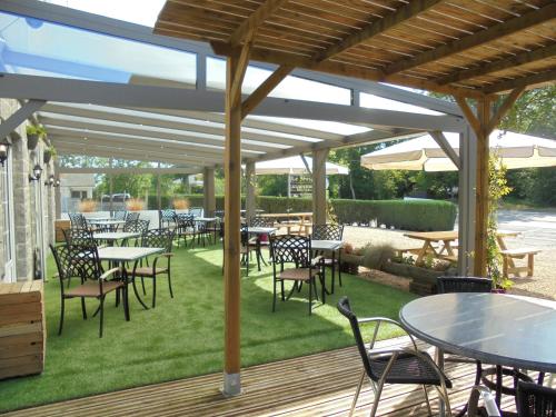 a patio with tables and chairs under a pavilion at Bed en Breakfast le freyr in Dinant
