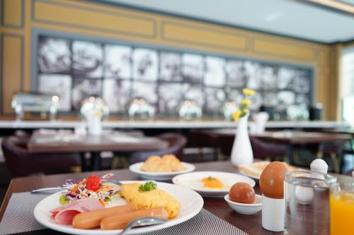 a table with plates of food on it in a restaurant at Picnic Hotel Bangkok - Rang Nam in Bangkok
