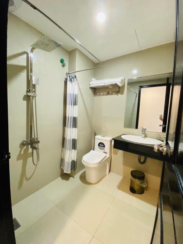 a bathroom with a toilet and a sink and a shower at Phuong Dong Hotel and Apartment in Quy Nhon