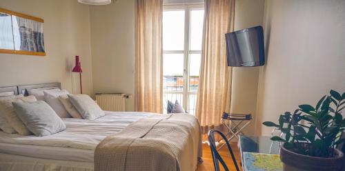 a bedroom with a bed and a tv and a window at Maritim Hotell & Krog in Simrishamn