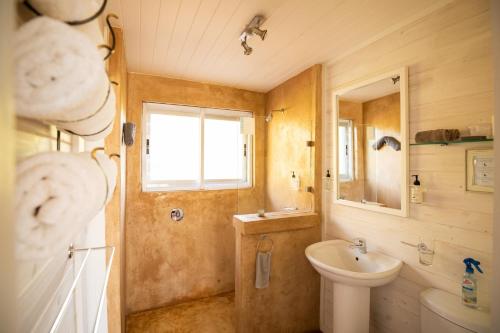 un bagno con lavandino, WC e specchio di Big Sky Cottages a Wolseley