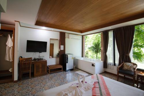 a hotel room with a bed and a television at Royal Train Garden Resort in Chiang Mai