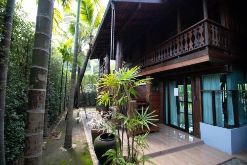 a house with palm trees in front of it at Royal Train Garden Resort in Chiang Mai