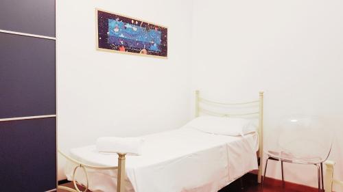 a bedroom with a white bed and two chairs at Villetta G in Senigallia