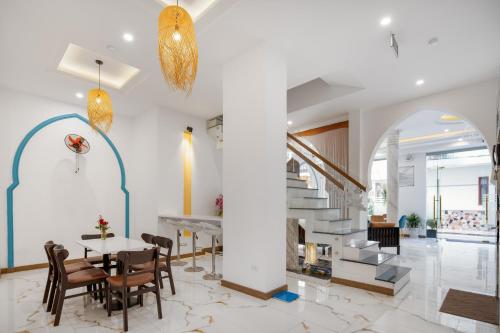 a lobby with a table and chairs and a staircase at Phuong Dong Hotel and Apartment in Quy Nhon