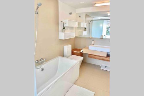 ein weißes Badezimmer mit einer Badewanne und einem Waschbecken in der Unterkunft HigueronRentals South Views in Benalmádena