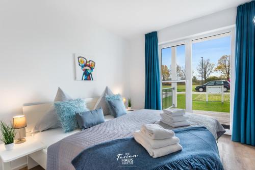 a bedroom with a bed with blue curtains and a window at Baltica in Olpenitz