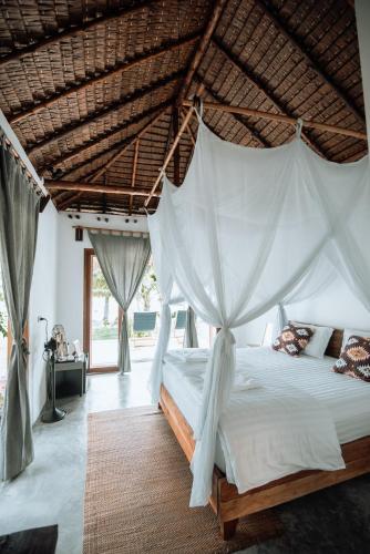 a bedroom with a bed with a mosquito net at Inhale @ Hill in Koh Mook