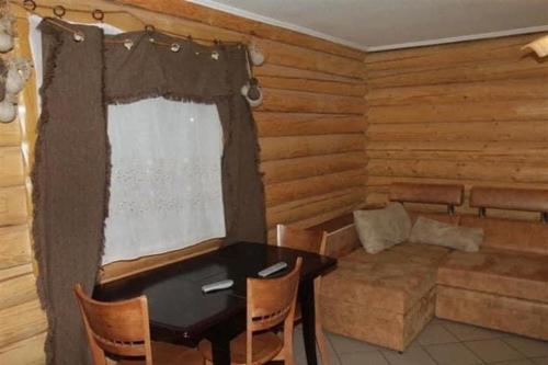 ein Wohnzimmer mit einem Tisch und einem Sofa in der Unterkunft Золото Карпат in Izky