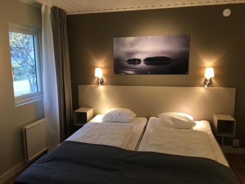 HestraにあるIsaberg Mountain Resortのベッド2台(壁にランプ2つ付)が備わるベッドルーム1室
