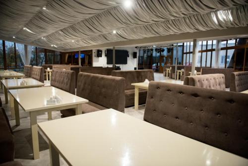 ein Restaurant mit weißen Tischen, Stühlen und Fenstern in der Unterkunft Holiday stay Nika in Busk