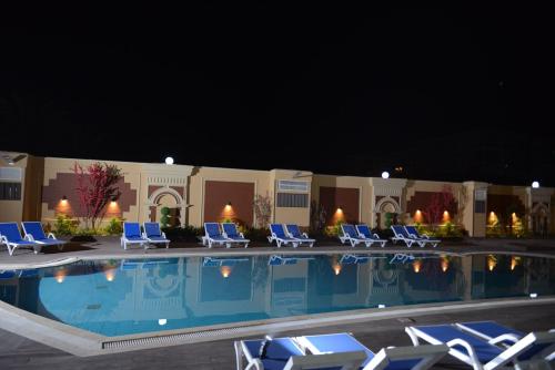 a pool with lounge chairs and a hotel at night at Eastern Al Montazah Hotel in Alexandria