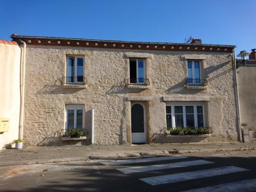 an old stone house with windows and a door at Maison De Village in Barbechat