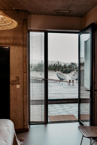 a bedroom with a sliding glass door to a patio at Strandhotel Zoomers in Castricum