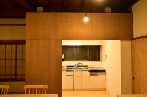 una cocina con armarios blancos y fregadero en 湊庵錆御納戸-so-an sabionand-, en Inatori