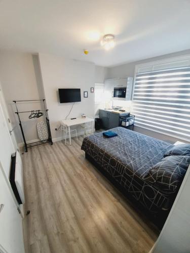 a bedroom with a bed and a desk in it at Southend on Sea - Westcliff Studios - Great Location in Southend-on-Sea