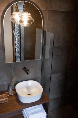 a bathroom with a sink and a mirror at Strandhotel Zoomers in Castricum