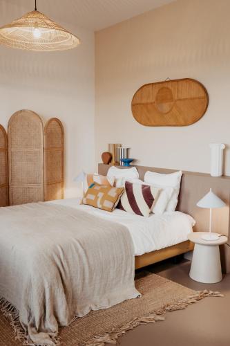 a bedroom with a large white bed with pillows at Strandhotel Zoomers in Castricum