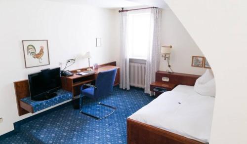 a hotel room with a bed and a desk with a computer at Hotel - Restaurant Traube in Neuffen