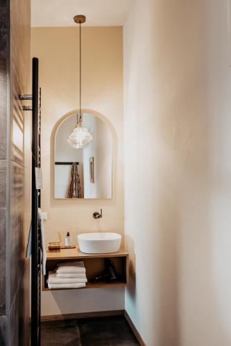 a bathroom with a sink and a mirror at Strandhotel Zoomers in Castricum