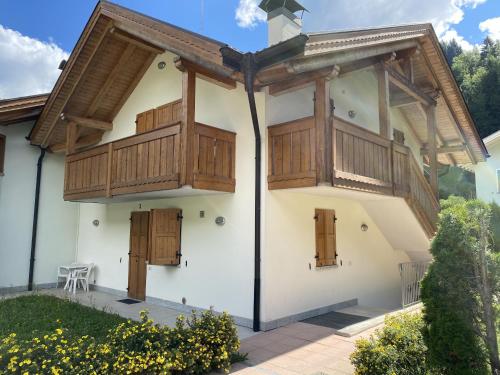 a house with wooden doors and a balcony at Residence Valentino in Pinzolo