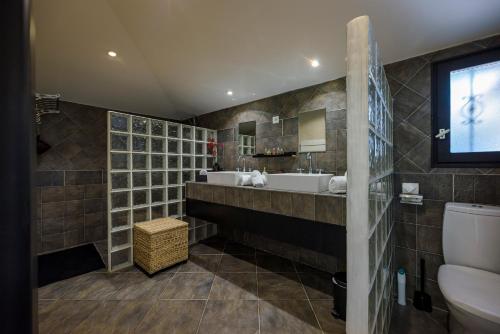 une salle de bain avec un lavabo et des toilettes dans l'établissement Les Villas de Palombaggia, à Porto-Vecchio
