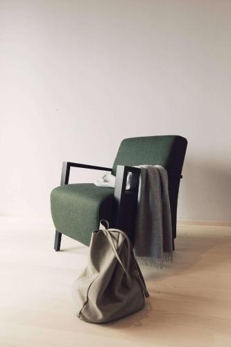 a green chair with a purse next to it at Hotel Milla Montis in Maranza