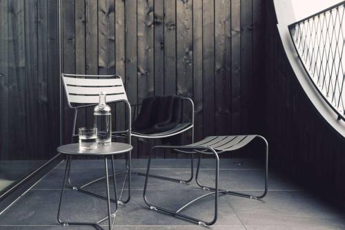 two chairs and a table with a bottle on it at Hotel Milla Montis in Maranza