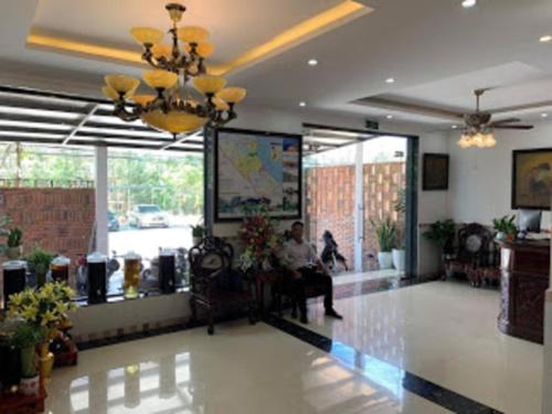 una persona sentada en una silla en un vestíbulo en Tuấn Anh 2 Hotel, en Dong Hoi