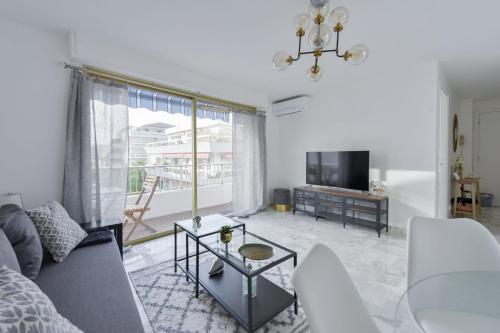 un salon avec un canapé et une table dans l'établissement Cannes Palm Beach district 2 min to the beaches, à Cannes
