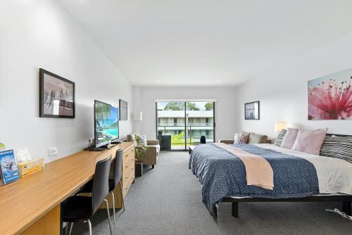 - une chambre avec un lit et un bureau avec une télévision dans l'établissement Sur la Plage - FREE WIFI & NETFLIX, à Cowes
