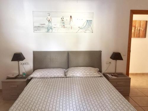 a bedroom with a bed and two pictures on the wall at Casa Tortuga in Caleta De Fuste
