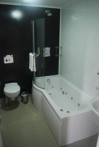 a bathroom with a tub and a toilet and a sink at The Radnorshire Arms Hotel in Presteigne