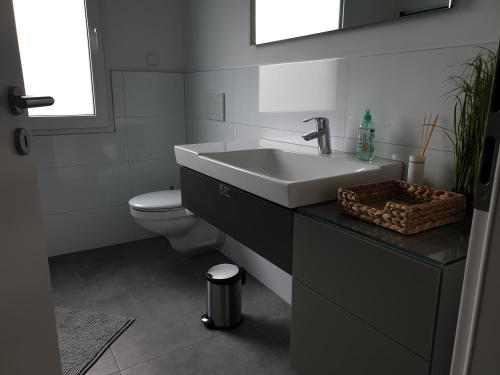 a bathroom with a sink and a toilet at BREUERS PulHEIM Appartment blau in Pulheim