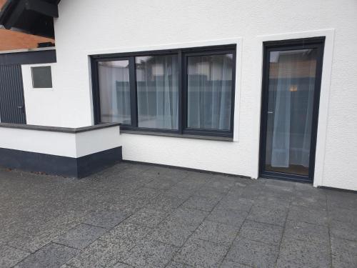 a white building with windows on the side of it at BREUERS PulHEIM Appartment blau in Pulheim