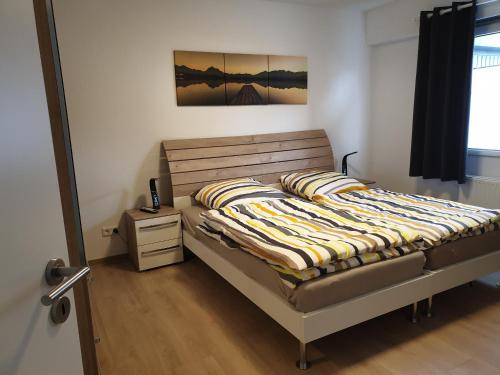 a bedroom with a bed with a wooden headboard at BREUERS PulHEIM Appartment blau in Pulheim