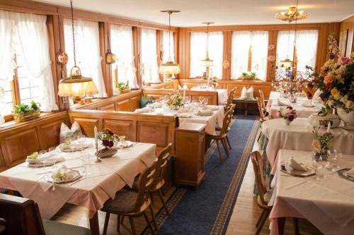 une salle à manger avec des tables et des nappes blanches dans l'établissement Hotel - Restaurant Traube, à Neuffen