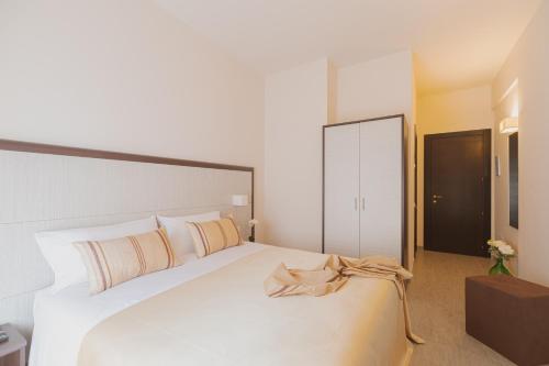 a bedroom with a large white bed and a dresser at La Maison Di Carla in Ancona