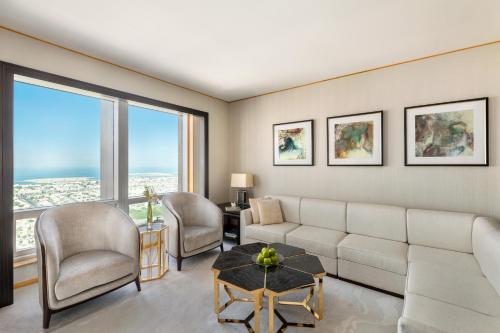a living room with a couch and chairs and windows at Shangri-La Dubai in Dubai