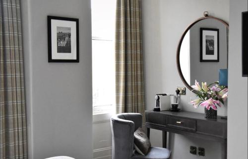 a room with a vanity and a mirror and a chair at Rooms at the Saint in St Andrews