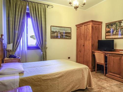 a bedroom with a bed and a desk and a television at Relais Il Mulino in Corigliano Calabro