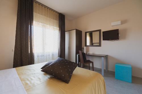 a bedroom with a bed and a desk and a window at La Maison Di Carla in Ancona