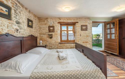 a bedroom with a large bed in a stone wall at House Peresiji in Peresiji